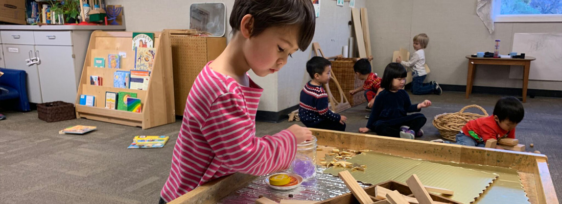 young child working on crafts at a table