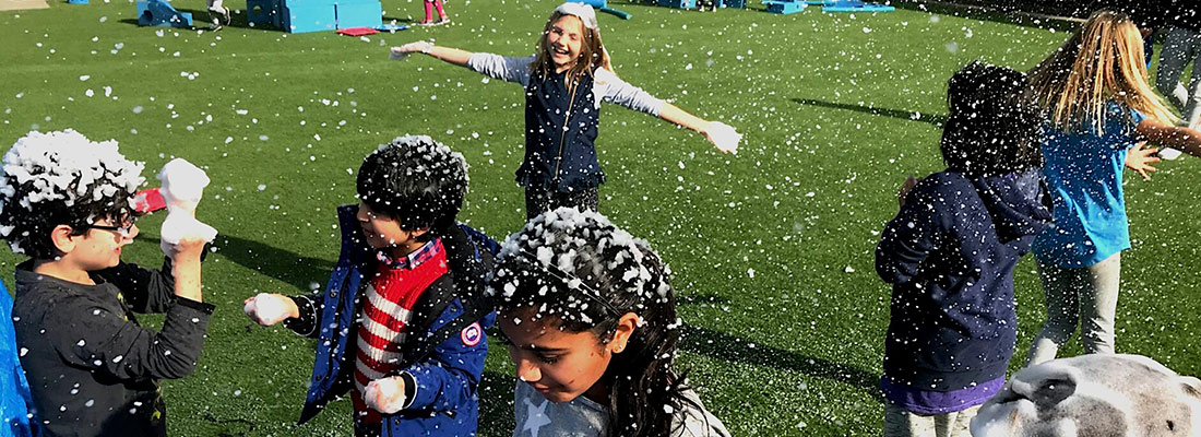 kids playing in snow on a field